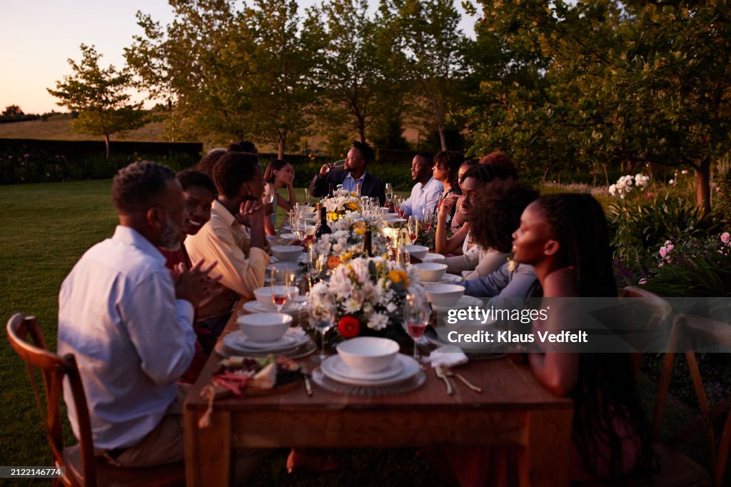 Wedding guests sitting together at long dining table