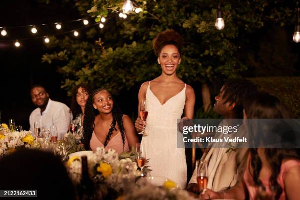 cheerful bride giving speech at dinner party - speech dinner stock pictures, royalty-free photos & images