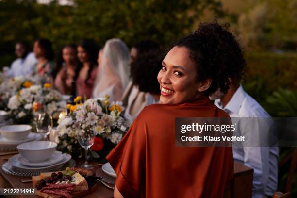 happy female guest looking back at dining table - guest stock pictures, royalty-free photos & images