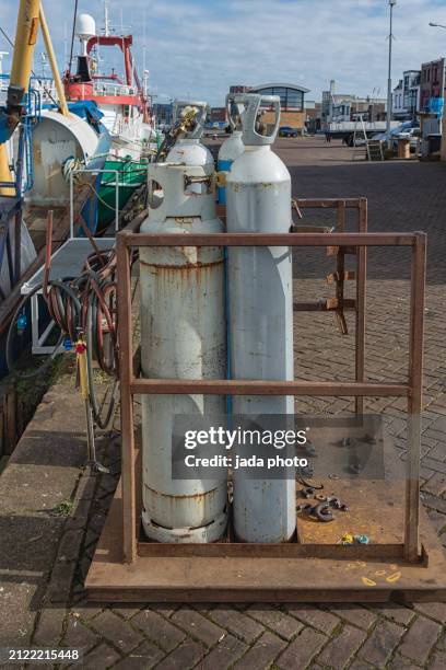 three gray steel liquid gas cylinders with a cutting torch - flammable stock pictures, royalty-free photos & images