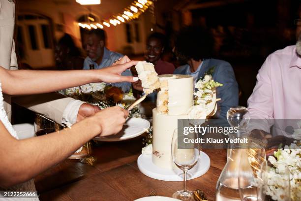 hands of newlywed couple cutting wedding cake near guests - 70s wedding black couple stock pictures, royalty-free photos & images