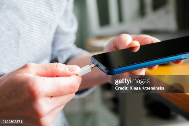 charging the phone - cargador de móvil fotografías e imágenes de stock