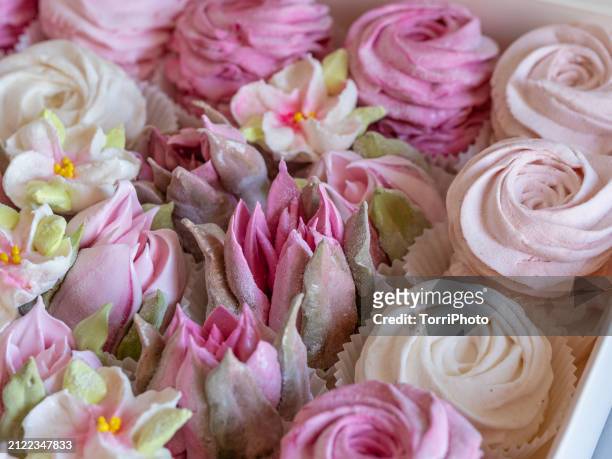 close-up pink and cream colored rosettes made from marshmallows, shaped like roses and tulips of different sizes stacked by the side of each other. zefir or zephyr flowers in the style of shabby chic - gelatin powder stock-fotos und bilder
