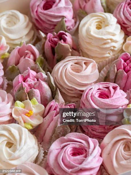 close-up pink and cream colored rosettes made from marshmallows, shaped like roses and tulips of different sizes stacked by the side of each other. zefir or zephyr flowers in the style of shabby chic - gelatin powder stock-fotos und bilder