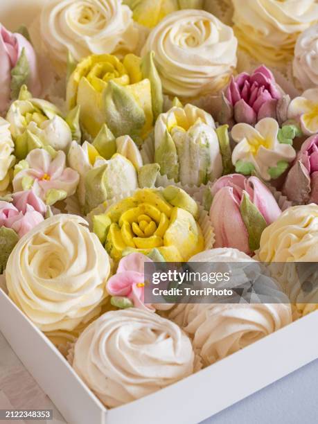 a white box containing yellow and cream colored rosettes made from marshmallows, shaped like roses of different sizes stacked by the side of each other. gift box of zefir. zephyr flowers in the style of shabby chic - gelatin powder fotografías e imágenes de stock