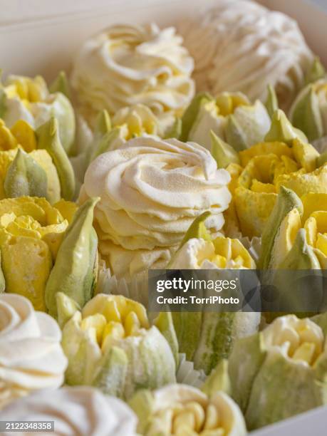 close-up yellow and cream colored rosettes made from marshmallows, shaped like roses and tulips of different sizes stacked by the side of each other. gift box of zefir. zephyr flowers in the style of shabby chic - gelatin powder stock pictures, royalty-free photos & images