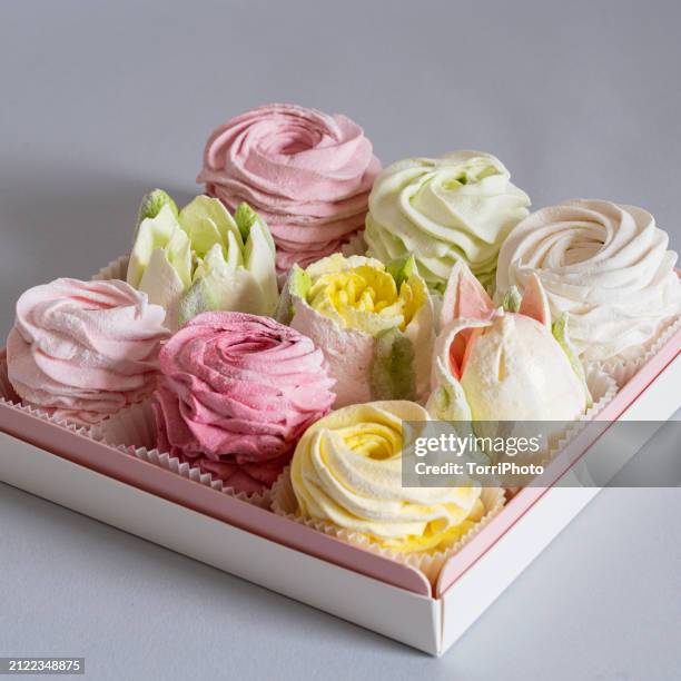 elegant colorful confections in a pink box, with a pink and cream color combination made from marshmallows, shaped like rosettes, roses and tulips of different sizes stacked by the side of each other. zefir or zephyr flowers in the style of shabby chic - gelatin powder stock-fotos und bilder