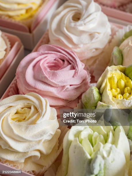 elegant colorful confections in a pink box, with a pink and cream color combination made from marshmallows, shaped like rosettes and tulips stacked by the side of each other. zefir or zephyr flowers in the style of shabby chic - gelatin powder stock-fotos und bilder