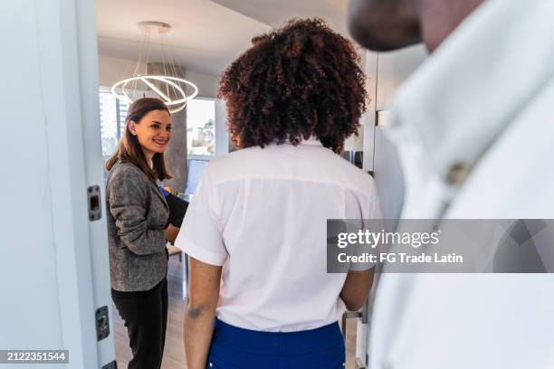 real estate agent showing house to a couple - ethnic millennial real estate stockfoto's en -beelden