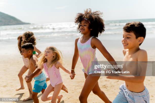 friends children running through the beach - black girls in swimsuits photos et images de collection