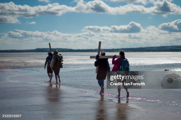 Pilgrims celebrate Easter by carrying wooden crosses as they walk over the tidal causeway to Lindisfarne during the final leg of their annual Good...