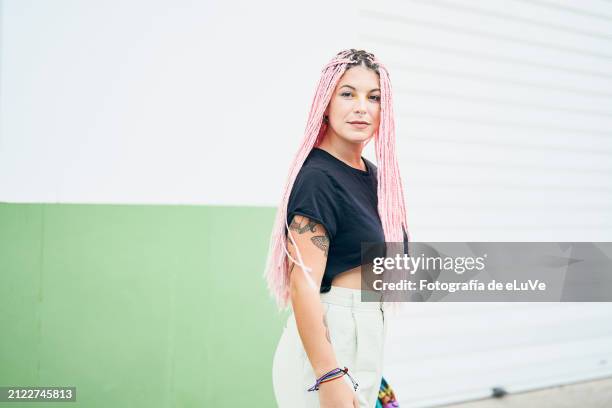 portrait of a young woman with pink hair looking at camera - andalucía de moda stock-fotos und bilder