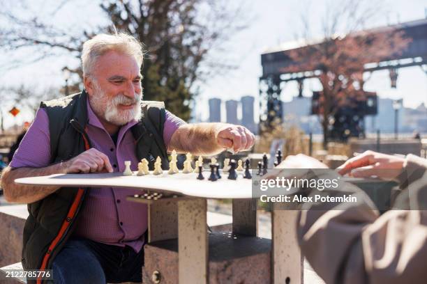brain training with chess: elderly plus-size retirees enjoy a game of chess at gantry plaza state park in queens, ny - check mate stock pictures, royalty-free photos & images
