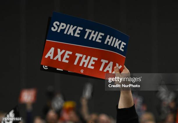 Supporter of Pierre Poilievre, the leader of Canada's Conservative Party, holds a placard during a 'Spike the Hike - Axe the Tax' rally in Edmonton,...