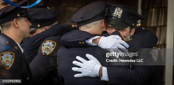 Massapequa Park, N.Y. : Police officers hugging after attending the funeral Wake held for New York Police Department Officer Jonathan Diller at...