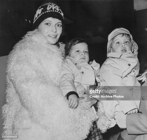 American actress Mia Farrow, with her twin sons, Sascha and Matthew, prepares to board her flight at Heathrow Airport in London, England, 13th...