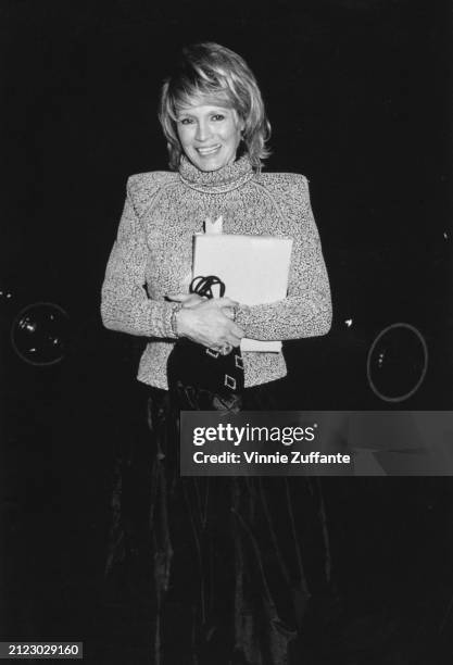 American actress Angie Dickinson, wearing a grey turtleneck sweater over a black evening gown, attends the 1987 Kennedy Center Honorees reception,...