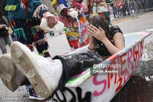 Girl is poured with water by men wearing traditional costumes to take part in the Smiergusty celebration in Wilamowice, Poland on April 1, 2024....