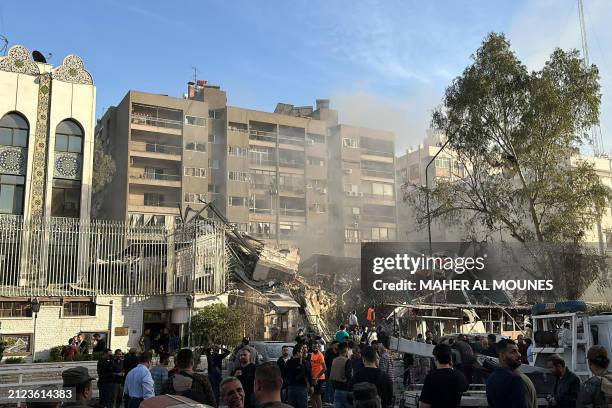 Emergency and security personnel gather at the site of strikes which hit a building next to the Iranian embassy in Syria's capital Damascus, on April...