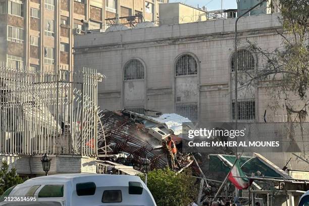 Emergency and security personnel gather at the site of strikes which hit a building next to the Iranian embassy in Syria's capital Damascus, on April...