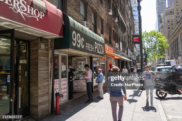 Cent pizza shop with the logo inscription 99c Fresh Pizza, also known as dollar slice in Manhattan, New York City. People enjoy and eat the low cost...