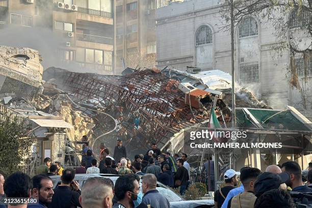 Emergency and security personnel gather at the site of strikes which hit a building next to the Iranian embassy in Syria's capital Damascus, on April...
