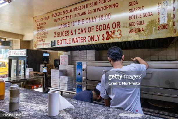 Inside a 99 cent pizza shop with the logo inscription 99c Fresh Pizza, also known as dollar slice in Manhattan, New York City. People enjoy and eat...