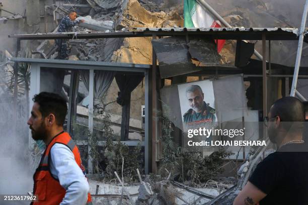 Emergency and security personnel work at the site of strikes which hit a building next to the Iranian embassy in Syria's capital Damascus, on April...