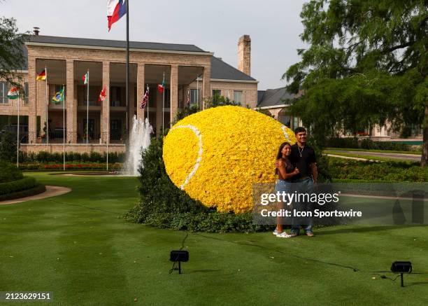 Fans pose in front of the large flower tennis ball during the US Clay Court Championship at River Oaks Country Club on April 1, 2024 in Houston,...