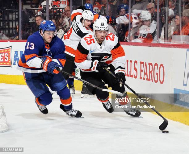 Ryan Poehling of the Philadelphia Flyers attempts to control the loose puck behind the net while being pursued by Mathew Barzal of the New York...