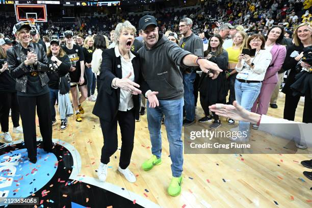 Head coach Lisa Bluder of the Iowa Hawkeyes celebrates with actor and producer Jason Sudeikis after defeating the LSU Tigers during the Elite Eight...