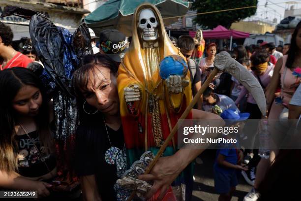 Person is holding an image of Santa Muerte outside the temple dedicated to her in Tepito, Mexico City, where 144 people are attending to give thanks...