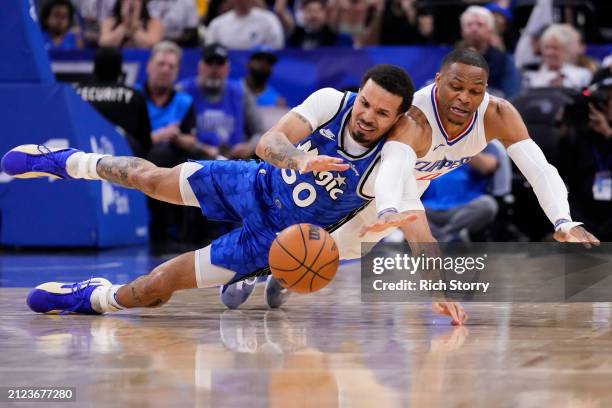 Cole Anthony of the Orlando Magic and Russell Westbrook of the Los Angeles Clippers compete for a loose ball during the first quarter at Kia Center...