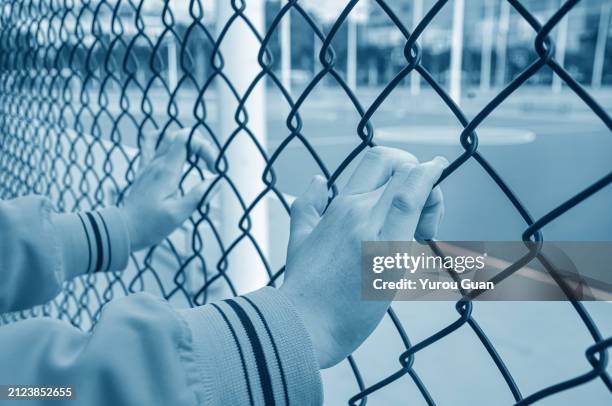 the prisoner put hands on the iron mesh.concept of freedom. - prison cell block stock pictures, royalty-free photos & images