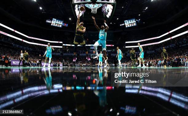 Stephen Curry of the Golden State Warriors attempts a lay up against Brandon Miller of the Charlotte Hornets during the first half of the game at...