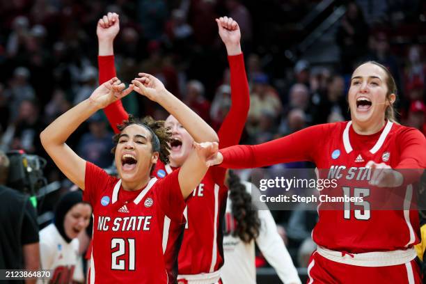 Madison Hayes, Maddie Cox, and Lizzy Williamson of the NC State Wolfpack celebrate after defeating the Stanford Cardinal 77-67 in the Sweet 16 round...