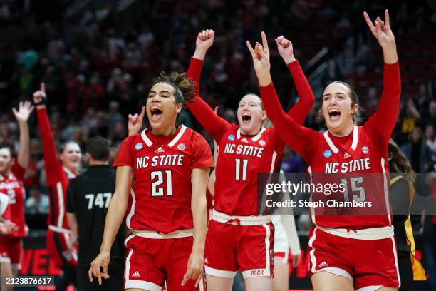 Madison Hayes, Maddie Cox, and Lizzy Williamson of the NC State Wolfpack celebrate after defeating the Stanford Cardinal 77-67 in the Sweet 16 round...