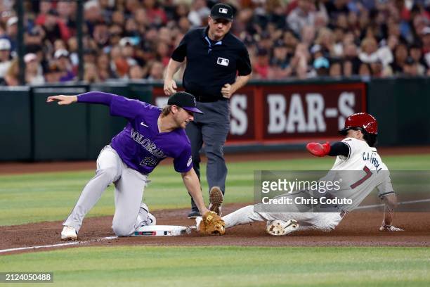 Corbin Carroll of the Arizona Diamondbacks is tagged out by Ryan McMahon of the Colorado Rockies attempting to steal third base during the fifth...