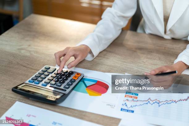 young asian female work with financial papers at home count on calculator before paying taxes receipts online - entrepreneur stockfoto's en -beelden