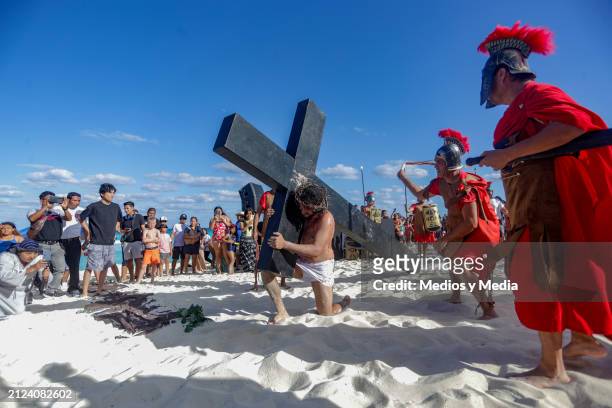 Man playing the role of Jesus Christ carries the cross during the representation of 'The Way of The Cross' as part of the Holy Week celebrations at...
