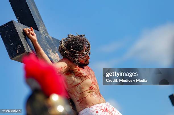 Man playing the role of Jesus Christ lies on the cross during the representation of 'The Way of The Cross' as part of the Holy Week celebrations at...