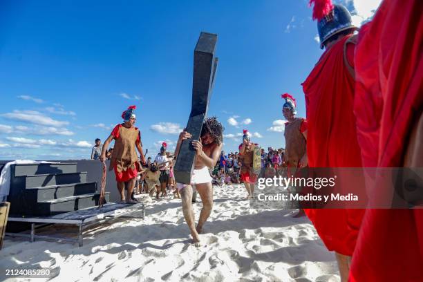 Man playing the role of Jesus Christ carries the cross during the representation of 'The Way of The Cross' as part of the Holy Week celebrations at...