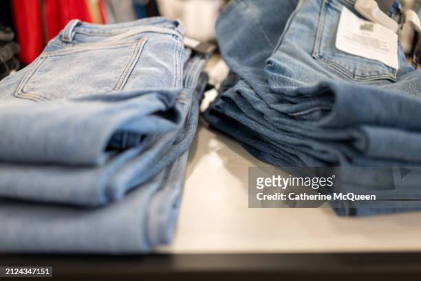 stacks of folded denim jeans - outlet store stock pictures, royalty-free photos & images