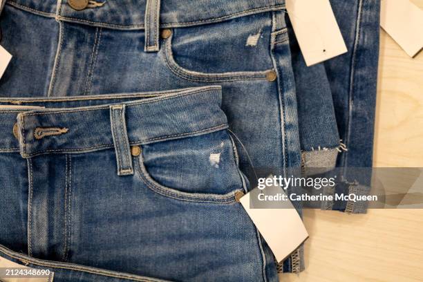 stacks of folded denim jean short shorts - denim pants stock pictures, royalty-free photos & images