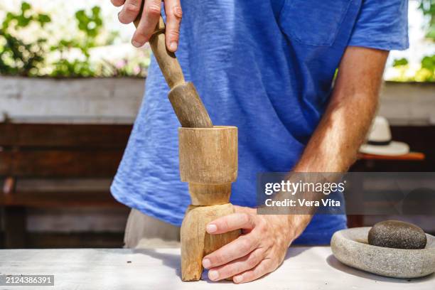 close up view of unrecognizable farmer hand grinding coffee beans selection in traditional kitchen - stone crop plant stock pictures, royalty-free photos & images