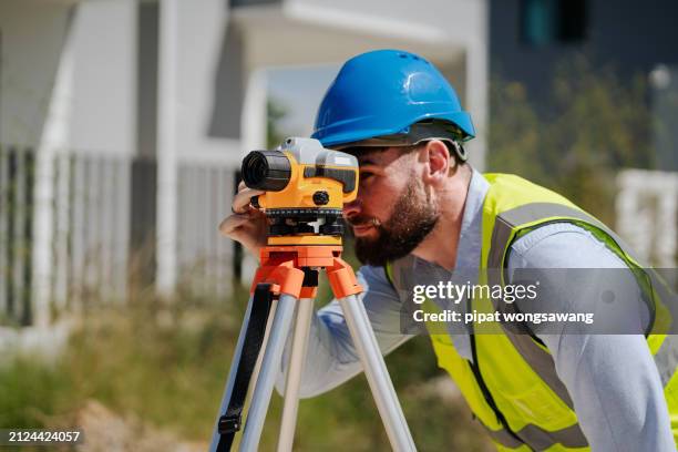 engineer is using a survey camera to measure levels on a construction site. - land surveyor stock pictures, royalty-free photos & images