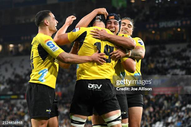 Justin Sangster of the Hurricanes celebrates with his team after scoring a try during the round six Super Rugby Pacific match between Highlanders and...