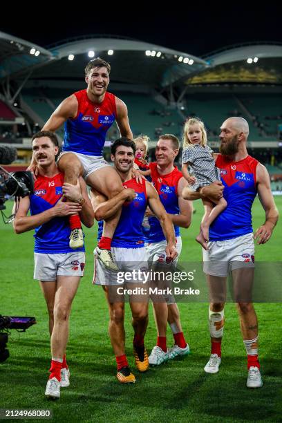 Jack Viney of the Demons is carried off for his 200th game by Jake Lever and Christian Petracca of the Demons with Steven May and Max Gawn of the...