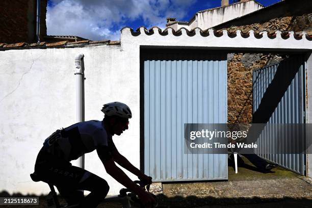 Silhouette of Jose Maria Garcia of Spain and Team Illes Balears Arabay Cycling in the breakaway passing through Zubielqui village while fans cheer...