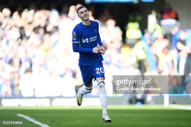 Cole Palmer of Chelsea celebrates scoring his team's first goal from a penalty kick during the Premier League match between Chelsea FC and Burnley FC...